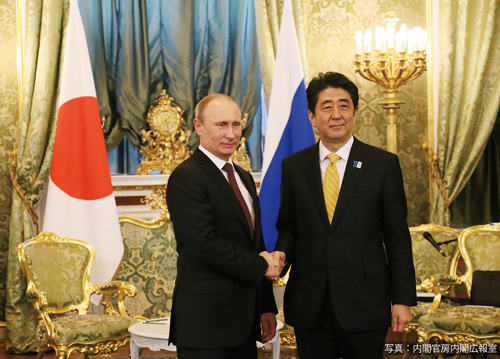 Премьер-министр Абэ и президент Путин пожимают руки на встрече на высшем уровне в Москве